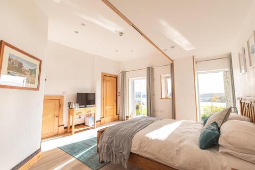 a bedroom with a large bed and a television at Coed y Berclas guest room, wonderful view in Llandegfan