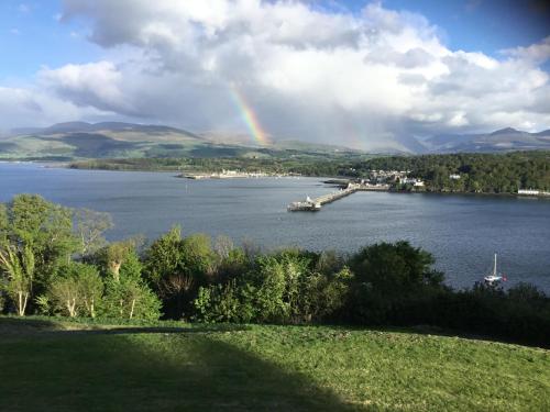 a rainbow over a large body of water at Coed y Berclas guest room, wonderful view in Llandegfan