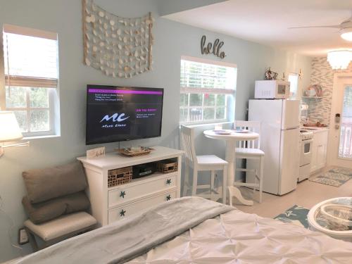 a bedroom with a television on a white dresser at Coastal Studio Escape! in Naples