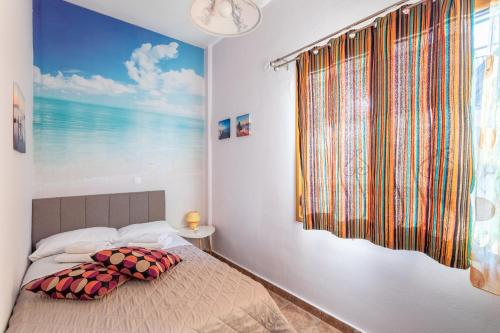 a bedroom with a bed with a large window at Cosy apartment in Stoupa in Stoupa