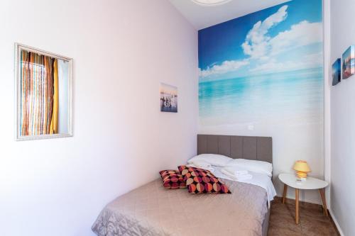 a bedroom with a bed with a painting on the wall at Cosy apartment in Stoupa in Stoupa
