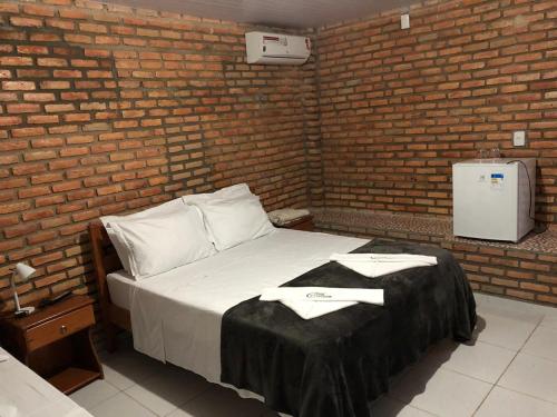 a bedroom with a bed in a brick wall at Chacara do Alemao in Flecheiras