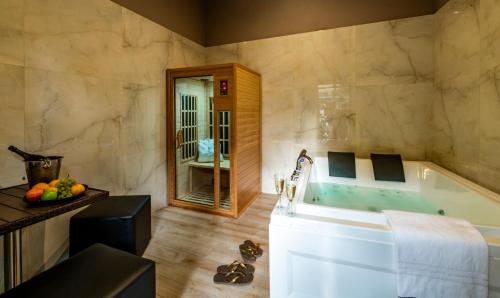 un ampio bagno con vasca e lavandino di Villa Elisio Hotel & Spa a Napoli