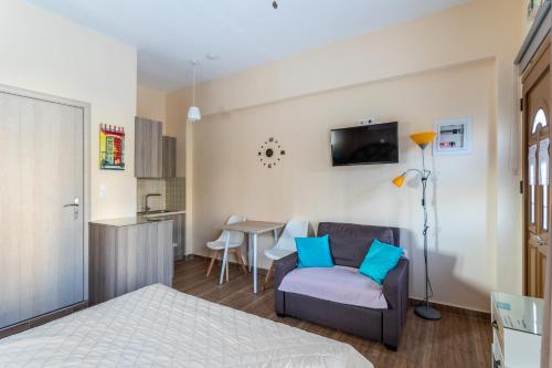 a bedroom with a bed and a couch and a table at Cosy studio 1 in Stoupa in Stoupa