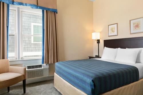 a hotel room with a bed and a chair and a window at Harrison Hall Hotel in Ocean City