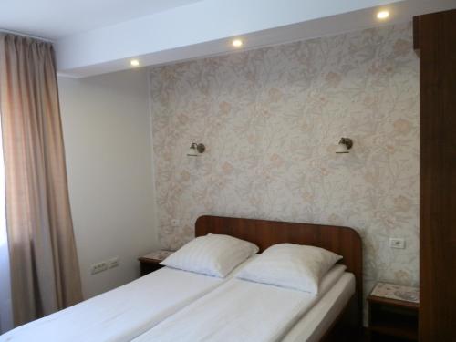 a bedroom with a bed with two pillows on it at Garsoniera Strada Bucegi in Sibiu
