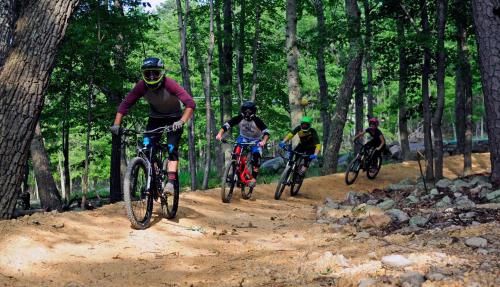 a group of people riding bikes on a dirt trail at Massanutten's Regal Vistas by TripForth in McGaheysville