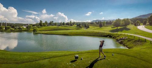 a woman standing on a golf course next to a lake at Massanutten's Regal Vistas by TripForth in McGaheysville