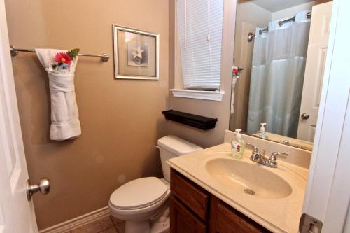 une salle de bain avec des toilettes blanches et un lavabo dans l'établissement Poolside Porch Paradise, à New Braunfels