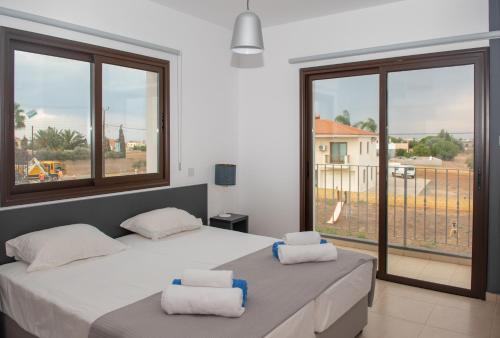 - une chambre avec 2 lits et une grande fenêtre dans l'établissement Villa Fortuna, à Ayia Napa