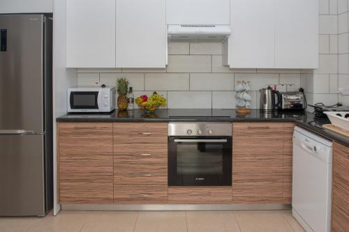 a kitchen with a stove and a microwave at Villa Fortuna in Ayia Napa