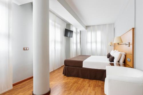 a hotel room with a bed and a white column at Exe Las Palmas in Las Palmas de Gran Canaria