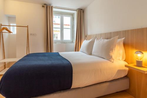 a bedroom with a large bed with white pillows at FS Boutique Downtown in Lisbon