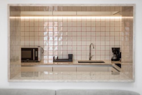 a tiled kitchen with a sink and a microwave at FS Boutique Downtown in Lisbon