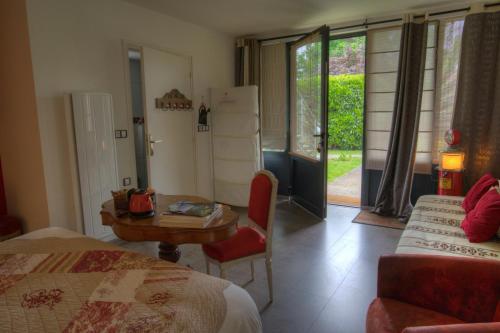 una camera con letto e tavolo e una camera con finestra di Maison Prairie Bonheur a Magny-les-Hameaux