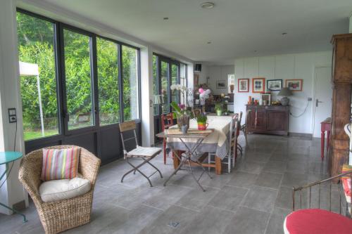 une cuisine et une salle à manger avec une table et des chaises dans l'établissement Maison Prairie Bonheur, à Magny-les-Hameaux