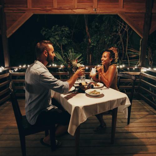 a man and woman sitting at a table in a restaurant at Sweet Songs Jungle Lodge in San Ignacio