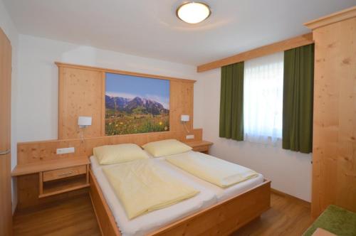 a bedroom with a large bed with a large window at Sonnenhof Walchsee in Walchsee