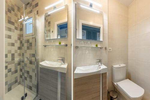 Apartamento Cuarta Puerta Centro Histórico في إشبيلية: حمام مع مغسلتين ودش ومرحاض