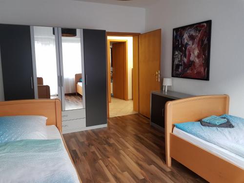 1 Schlafzimmer mit 2 Betten und einem Spiegel in der Unterkunft Große Ferienwohnung an der Rheinpromenade three in Duisburg