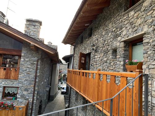 a stone building with a wooden fence and a balcony at Il Cuore della Valdigne - Courmayeur-La Thuile- Pré Saint Didier in Morgex