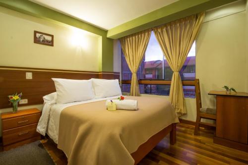 クスコにあるLa Parada Cusco Hotelの窓のある大きなベッドのある寝室