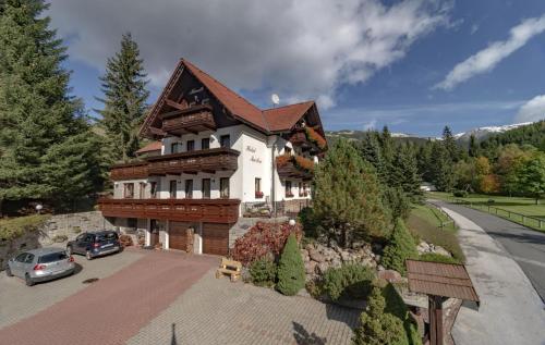 a house with a car parked in front of it at Hotel Resort Martin & Kristyna in Špindlerův Mlýn