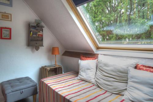 
a room with a bed, chair and window at Cottage Prairie Bonheur in Magny-les-Hameaux
