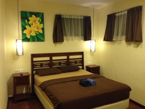 a bedroom with a bed with a hat on it at Bemo Corner Guest House in Kuta