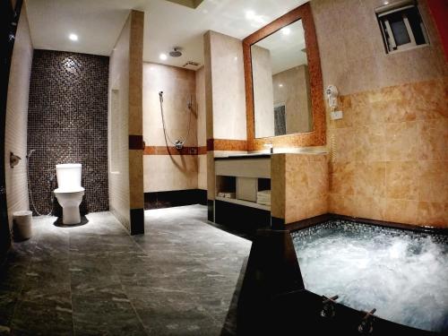 a bathroom with a tub and a sink and a toilet at Song Xia Motel in Dali