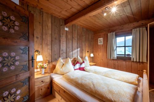 1 dormitorio con 2 camas en una habitación con paredes de madera en Weberhäusl en Hopfgarten im Brixental