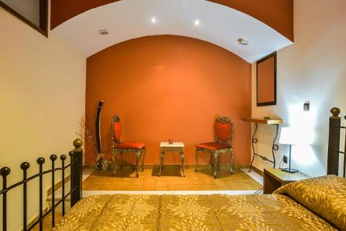 a bedroom with two red chairs and a bed at Abelos Villas in Áyios Ioánnis