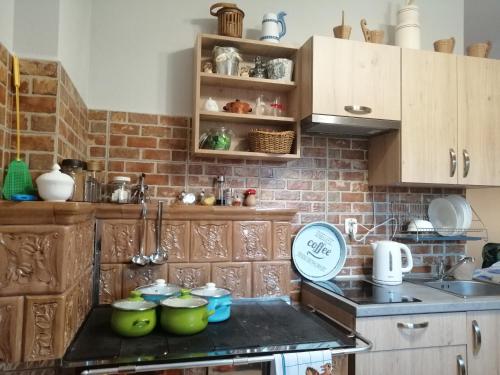 a kitchen with wooden cabinets and green bowls on the counter at Ranczo pod Klimoską in Rzyki