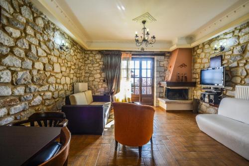 a living room with a stone wall at Abelos Villas in Áyios Ioánnis
