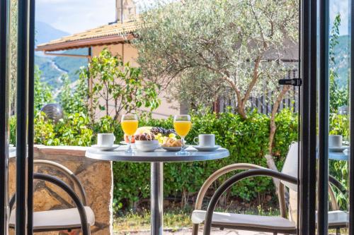 a table with two glasses of orange juice and a plate of food at Thermios Apollon in Thermo