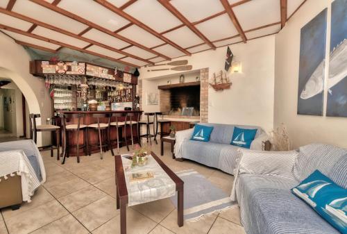 a living room with couches and a bar at Mermaid Guest House in Struisbaai