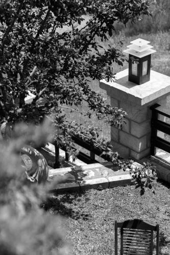 a bird sitting on a bench next to a bird house at Abelos Villas in Áyios Ioánnis