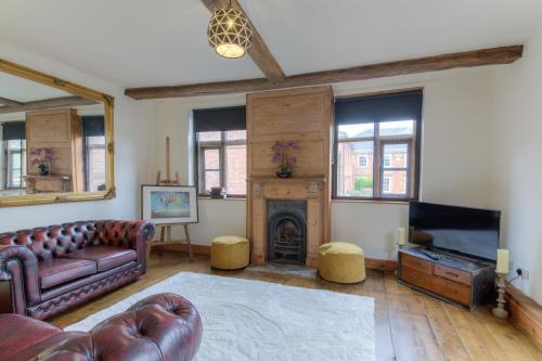 a living room with a couch and a fireplace at Octagon Cottage in Norwich