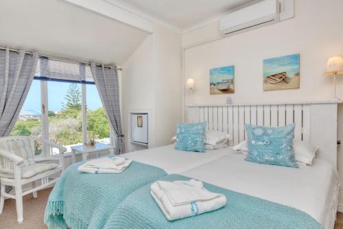 a bedroom with two beds and a window at Mermaid Guest House in Struisbaai