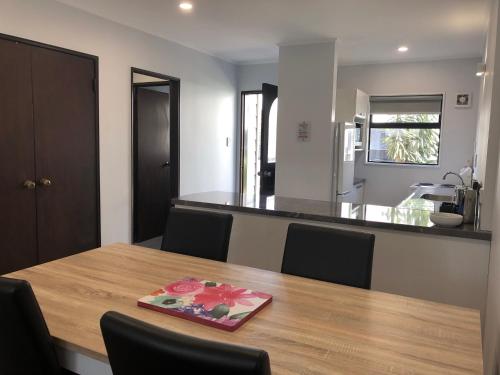 a dining room table with chairs and a kitchen at Hacienda Motor Lodge in Palmerston North