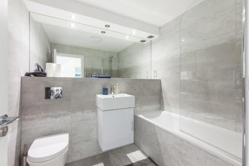 uma casa de banho com um WC, uma banheira e um lavatório. em Powis Square em Londres