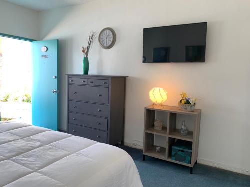 a bedroom with a bed and a dresser and a tv at International Inn on the Bay in Miami Beach