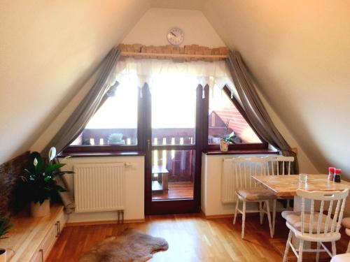a dining room with a table and a large window at Apartman Aisha in Veľká Lomnica