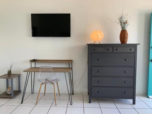 a bedroom with a dresser and a desk and a tv at International Inn on the Bay in Miami Beach