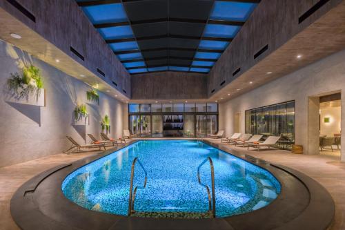 a swimming pool in a building with a ceiling at Mövenpick Hotel du Lac Tunis in Tunis