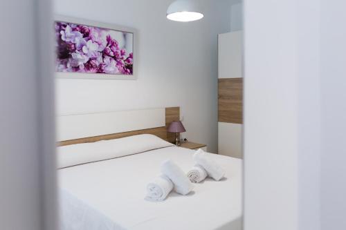 1 Schlafzimmer mit 2 weißen Betten mit Blumen an der Wand in der Unterkunft COLUMBUS´ HOME in Córdoba