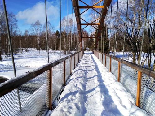 a bridge covered in snow with a fence at Apartmány Stožec - Bella Premium in Stožec