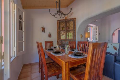 a dining room with a wooden table and chairs at Charming Seaside Cottage Casa Rosa - Somewhere Special in Luz de Tavira