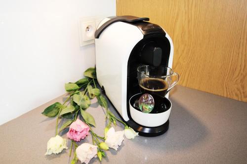 a coffee maker sitting on a counter with a glass at Aqua Apartments Sunset in Reda