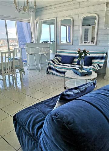 un salon avec des canapés bleus et une table dans l'établissement F3, 6 Pers, BELLE VUE PANORAMIQUE MER, à Berck-sur-Mer